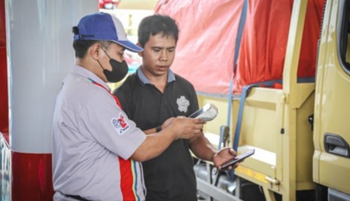 Petugas SPBU sedang mengisi BBM ke konsumen.