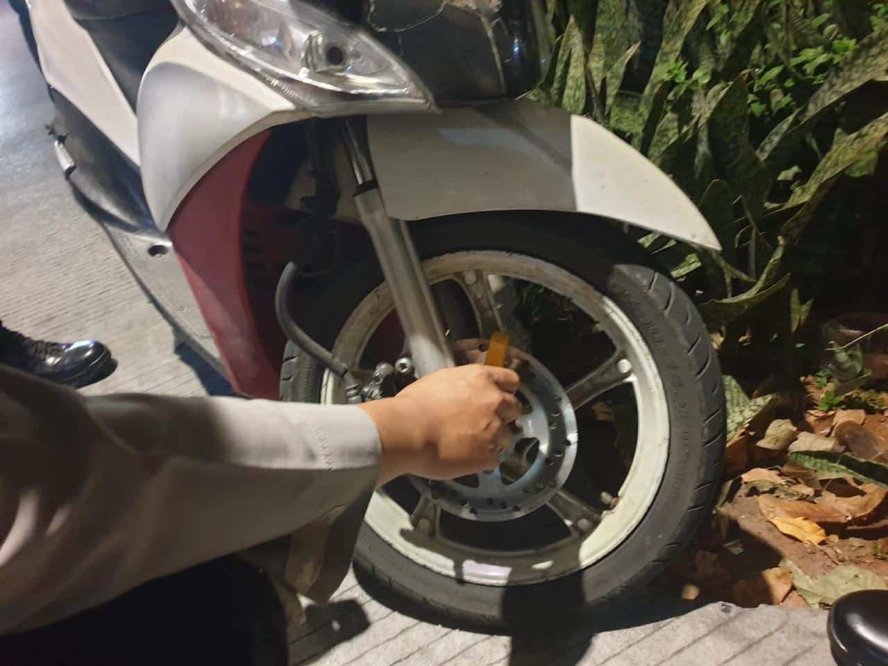 Petugas Polsek Grogol Petamburan menggembok motor yang parkir sembarangan di pinggir jalan. (Aris MP)