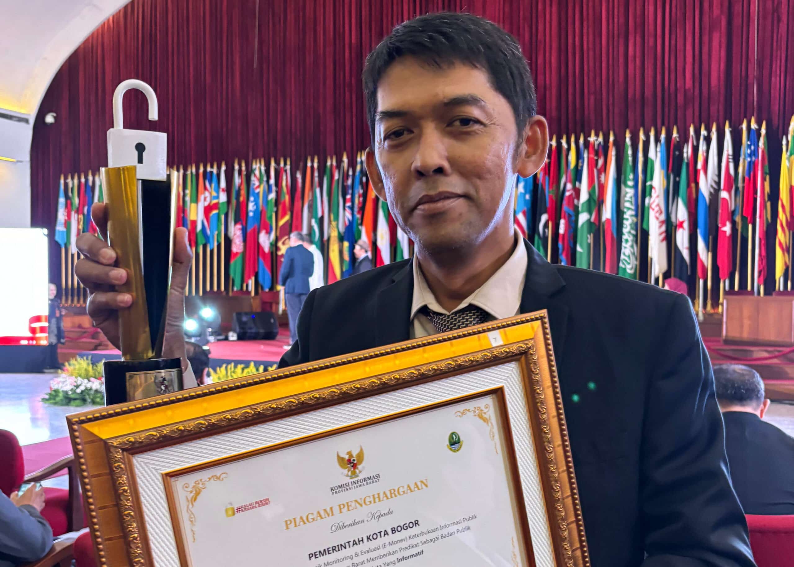 Kadis Kominfo Kota Bogor, Rahmat Hidayat, menunjukkan penghargaan E-Monev Keterbukaan Informasi Publik 2024 (KIS/NICKO)