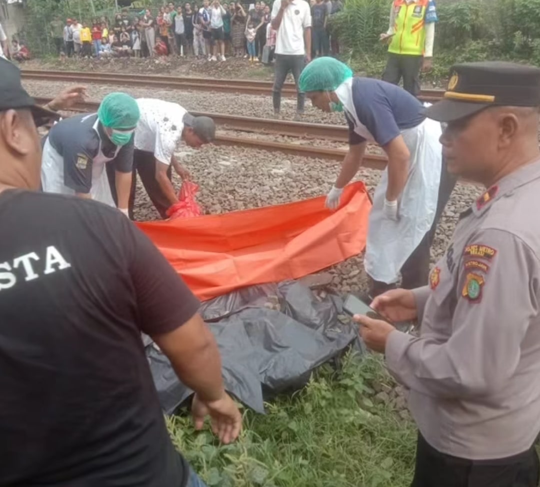 Petugas mengevakuasi wanita tewas tertabrak kereta di perlintasan rel Tambun Selatan. (dok. Polsek Tambun Selatan)