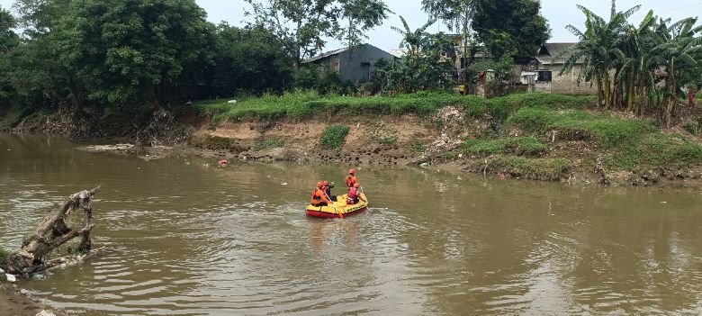 Petugas gabungan mencari keberadaan kakak beradik yang hanyut di Kali Bekasi. (Joy)
