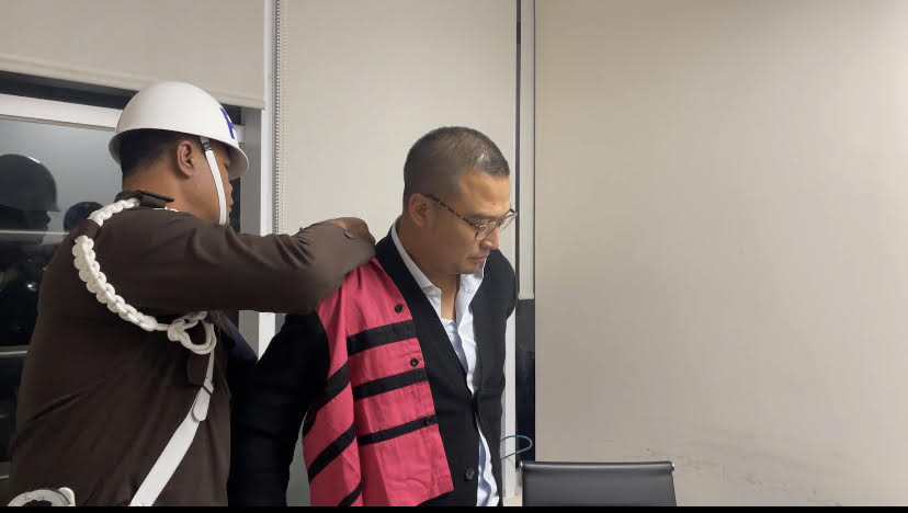 Petugas Kejagung mengenakan baju rompi tahanan kepada salah satu tersangka korupsi impor BBM di Pertamina.(Ist)