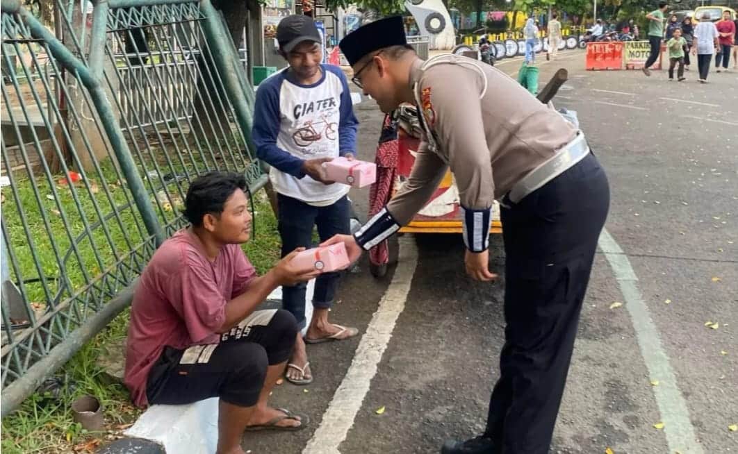 Personel Polantas Polda Metro Jaya memberikan takjil kepada warga. (Ist)