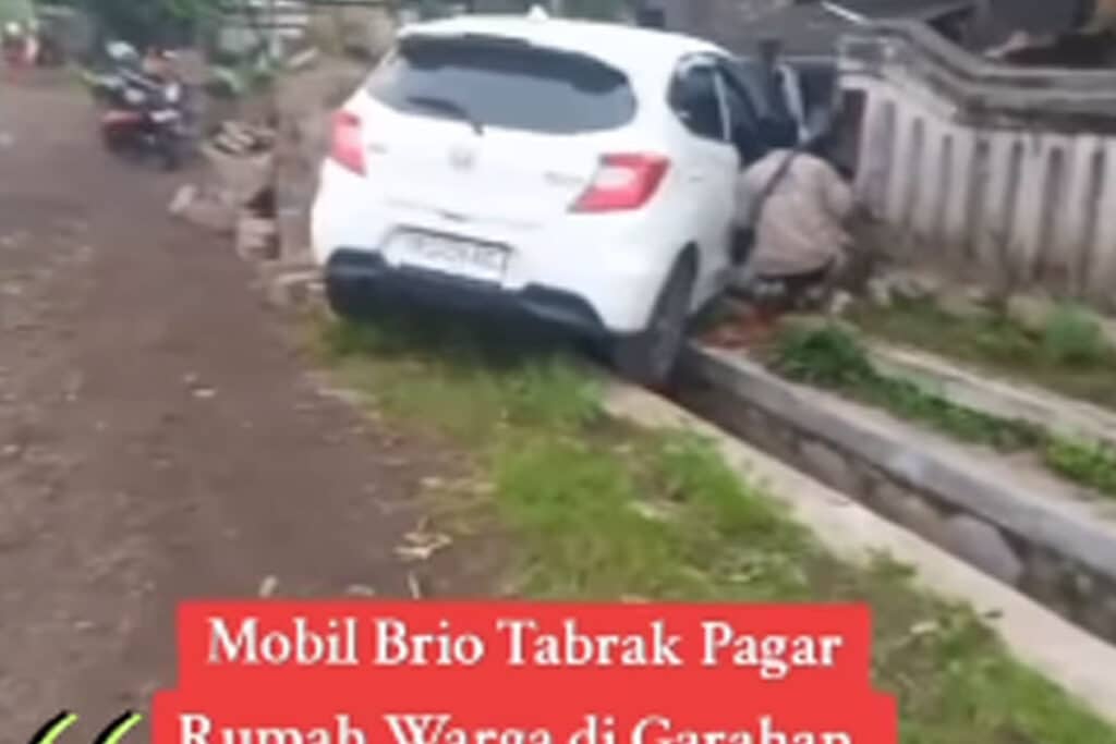 Diduga Kaget saat Disalip, Mobil Putih Tabrak Tembok Rumah Warga Jember
